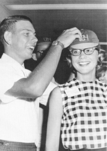 A junior helps a freshman adjust her beanie in 1964.